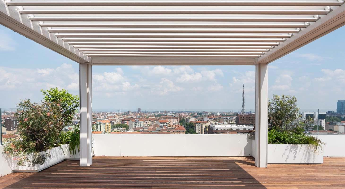 Bela bioklimatska pergola na strešni terasi z lesenim podom in razgledom na mestno panoramo.