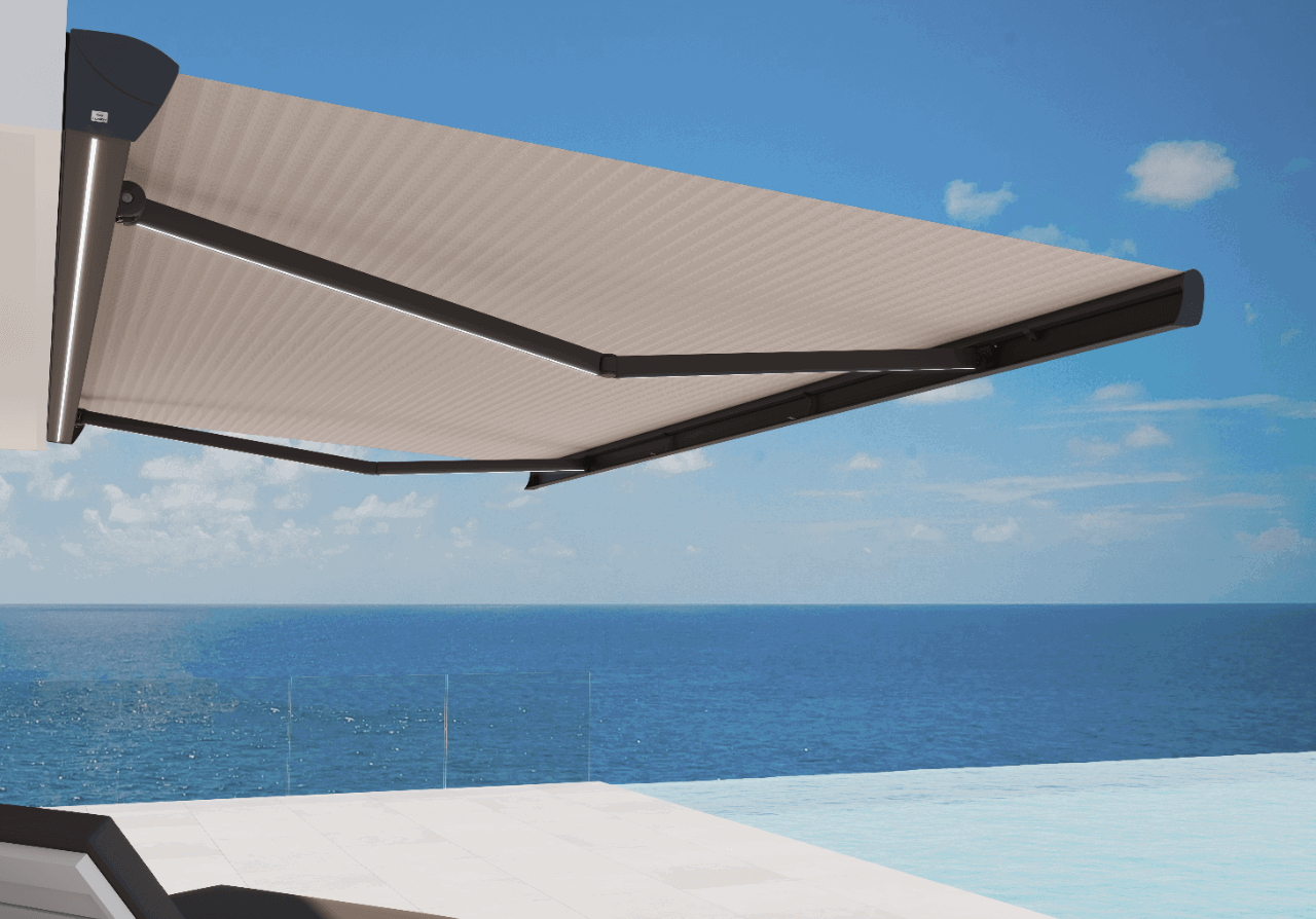 Odprta kasetna tenda s črtastim platnom in raztegljivimi rokami v črni barvi, nameščena na fasado z razgledom na morje.